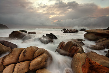 Image showing Ocean surges over weathered rocks