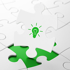 Image showing Finance concept: Light Bulb on puzzle background