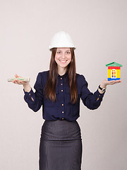 Image showing Young beautiful girl offering to buy a house