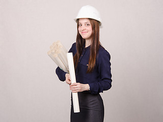 Image showing Student stands with blueprints in hand