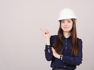 Image showing Woman engineer in helmet points finger to right