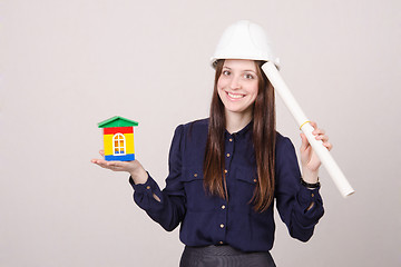 Image showing young girl stands with house and drawing in hands of