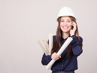 Image showing Engineer talking on phone with blueprints in hand