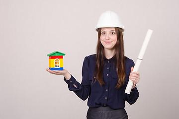 Image showing Girl helmet with house worth and drawing in hands