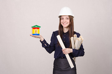 Image showing Woman architect with a house worth and drawing in hands