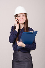 Image showing Construction worker talking to a customer on phone