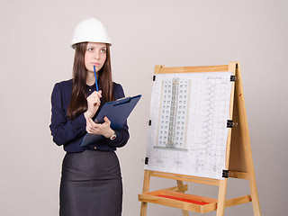 Image showing Woman architect on project thought of a multistory building