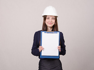Image showing Girl a helmet standing with folder and leaf in it