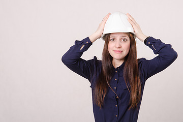 Image showing Frustrated young girl put her hands on his helmet