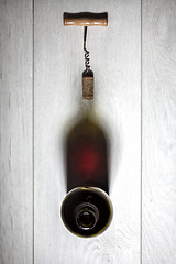 Image showing Bottle of red wine with cork on white wooden table