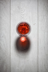 Image showing Glass of red wine on wooden table.