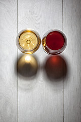 Image showing Glasses of red and white wine on wooden table