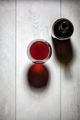 Image showing Glass and bottle of red wine with cork on table