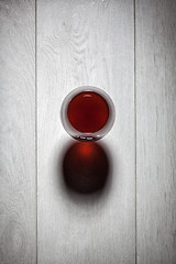 Image showing Glass of red wine on wooden table.