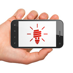 Image showing Finance concept: Energy Saving Lamp on smartphone