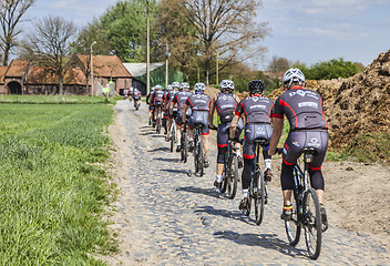 Image showing Amateur Cyclists on a Cobblestone Road