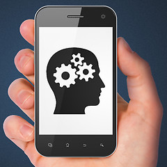 Image showing Advertising concept: Head With Gears on smartphone