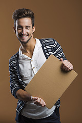 Image showing Young man holding a card board