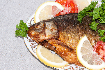 Image showing Fresh crucian river fish fried in lemon juice and fresh herbs.