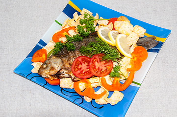 Image showing Fresh crucian river fish fried in lemon juice and fresh herbs.