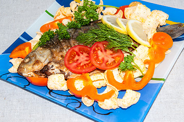 Image showing Fresh crucian river fish fried in lemon juice and fresh herbs.