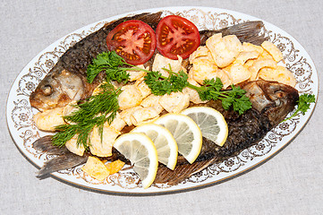 Image showing Fresh crucian river fish fried in lemon juice and fresh herbs.