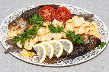 Image showing Fresh crucian river fish fried in lemon juice and fresh herbs.