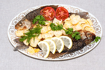 Image showing Fresh crucian river fish fried in lemon juice and fresh herbs.