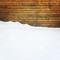 Image showing Empty space covered by snow near a wooden wall