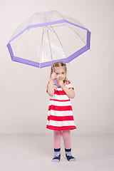 Image showing Three year old girl raised her umbrella