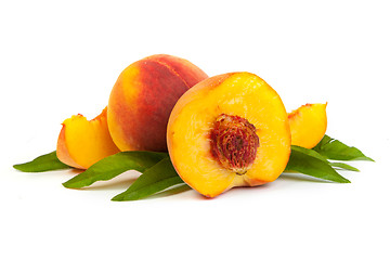 Image showing Three perfect, ripe peaches with a half  and slices isolated on 