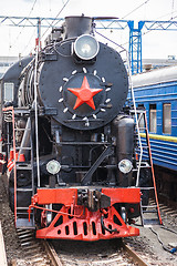 Image showing Old steam train is leaving a station