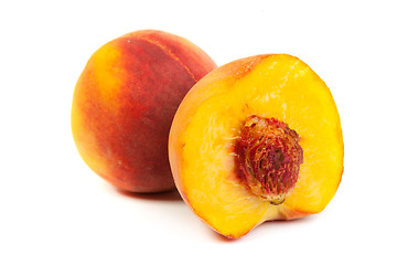 Image showing Three perfect, ripe peaches with a half  and slices isolated on 