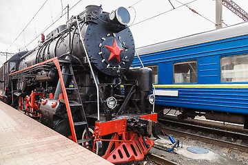 Image showing Old steam train is leaving a station