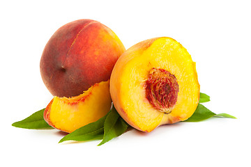 Image showing Three perfect, ripe peaches with a half  and slices isolated on 