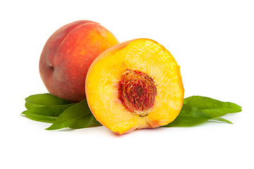 Image showing Three perfect, ripe peaches with a half  and slices isolated on 