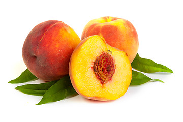 Image showing Three perfect, ripe peaches with a half  and slices isolated on 