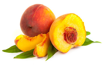 Image showing Three perfect, ripe peaches with a half  and slices isolated on 