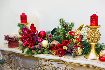 Image showing A fireplace mantle is decorated for Christmas with garland, ligh