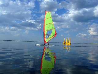 Image showing Windsurfer and its reflection in water of a gulf