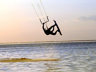 Image showing Silhouette of a kitesurf, a flying above water of a gulf