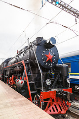 Image showing Old steam train is leaving a station