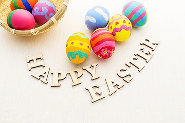 Image showing Painted easter egg in basket with wooden text