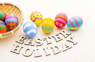 Image showing Colourful easter egg in basket and wooden letter