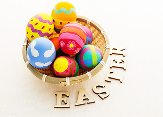 Image showing Easter egg in basket and wooden text