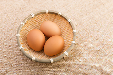 Image showing Egg in basket over linen background