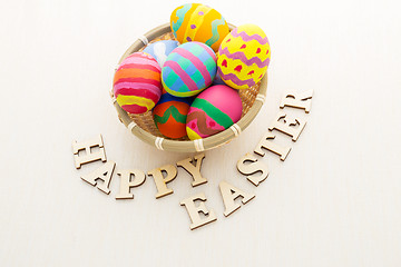 Image showing Easter egg in basket with wooden text