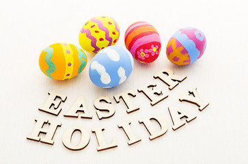 Image showing Kid drawing easter egg with wooden text