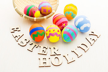 Image showing Painted easter egg in basket with wooden text