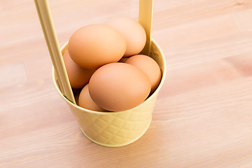 Image showing Brown egg in bucket